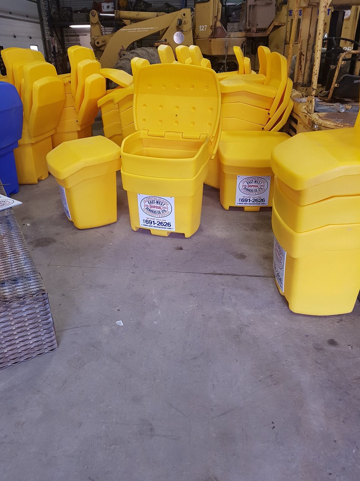 East-West branded yellow de-icing salt bins stocked at a Toronto commercial property